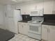 Well-lit kitchen featuring white cabinets, countertops, and modern appliances at 4109 Fairview Vista Pt # 315, Orlando, FL 32804