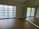 Open living room with wood floors and expansive glass doors offering water views and mirrored wall at 4109 Fairview Vista Pt # 315, Orlando, FL 32804