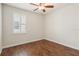 A bright bedroom with a ceiling fan, window with blinds, and beautiful wood-style flooring at 453 Kays Landing Dr, Sanford, FL 32771