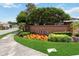 Inviting community entrance with a brick sign, lush greenery, and colorful flowers creating a welcoming atmosphere at 453 Kays Landing Dr, Sanford, FL 32771