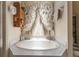 Close-up of a soaking tub with ruffled curtain in a well-lit bathroom at 4561 Heritage Oak Dr, Orlando, FL 32808