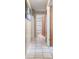 Bright hallway with tile flooring, neutral walls, and a view into an adjacent bathroom at 4561 Heritage Oak Dr, Orlando, FL 32808