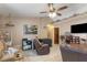 Living area featuring a ceiling fan, tile floors, and a large TV for entertainment at 4561 Heritage Oak Dr, Orlando, FL 32808