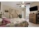Cozy main bedroom featuring a ceiling fan, patterned quilt, and access to the bathroom at 4561 Heritage Oak Dr, Orlando, FL 32808
