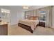Well-lit bedroom with plush carpet, a queen bed, and an ensuite bathroom at 4983 Windermere Ave, Kissimmee, FL 34746