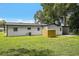 Large backyard showcasing the home's white exterior, well-maintained lawn, and ample space for outdoor activities at 50 Community Dr, Debary, FL 32713