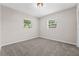 Cozy carpeted bedroom with natural light streaming through two windows at 50 Community Dr, Debary, FL 32713