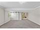 Spacious carpeted bedroom featuring natural light from two windows and a stylish barn door entry at 50 Community Dr, Debary, FL 32713
