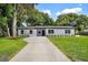 Charming single-story home featuring a well-maintained front yard and a long concrete driveway at 50 Community Dr, Debary, FL 32713