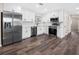 Modern kitchen features sleek stainless steel appliances, pristine white cabinetry, and stylish hardwood floors at 50 Community Dr, Debary, FL 32713