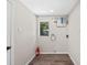 Bright laundry room with wood-look floors, utility hookups, and a window for natural light at 50 Community Dr, Debary, FL 32713