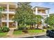 Condo exterior features well-maintained landscaping, white railing balconies, and a beautifully flowering tree at 510 Rum Run # 33 510, Davenport, FL 33837
