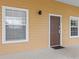 Charming home exterior featuring a brown front door, light beige siding, and white trim at 510 Rum Run # 33 510, Davenport, FL 33837