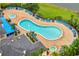An aerial shot showcases a large, uniquely shaped pool surrounded by lounge chairs and palm trees, perfect for relaxation at 510 Rum Run # 33 510, Davenport, FL 33837