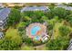 Overhead view of a uniquely shaped pool and spa area surrounded by trees and lounge chairs with green grass at 510 Rum Run # 33 510, Davenport, FL 33837