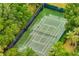 Overhead view of a meticulously maintained tennis court surrounded by lush greenery at 510 Rum Run # 33 510, Davenport, FL 33837