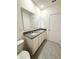 Bathroom featuring a double granite vanity and modern fixtures with a large mirror and tiled floor at 5168 Greenheart Ave, Mount Dora, FL 32757