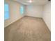 A spacious carpeted bedroom with two windows providing natural light at 5168 Greenheart Ave, Mount Dora, FL 32757
