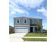 Two-story home with a gray facade, well-manicured lawn, and a two-car garage at 5168 Greenheart Ave, Mount Dora, FL 32757