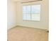 Carpeted bedroom with a large window and neutral paint at 5216 Greenheart Ave, Mount Dora, FL 32757
