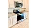 A close up of the kitchen with stainless steel oven and microwave, granite counters and white cabinets at 5216 Greenheart Ave, Mount Dora, FL 32757