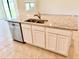 Stylish kitchen island features stainless steel dishwasher, granite counters and white cabinetry at 5216 Greenheart Ave, Mount Dora, FL 32757