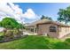 Exterior view of the backyard featuring lush lawn, mature trees, and a covered sunroom offers a peaceful retreat at 603 Yorkshire Dr, Oviedo, FL 32765