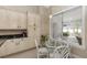 Bright breakfast nook features a glass table, white wicker chairs, and a view of the sunroom at 603 Yorkshire Dr, Oviedo, FL 32765