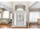 Bright foyer with grand arched window above front door, hardwood floors, and sheer white curtains creating an airy ambiance at 603 Yorkshire Dr, Oviedo, FL 32765