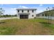 Spacious backyard features a grassy area and a view of the home's rear exterior at 6454 Chorus Dr, Mascotte, FL 34753