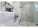 A modern bathroom featuring marble walls, a soaking tub, and a glass walk-in shower at 6454 Chorus Dr, Mascotte, FL 34753