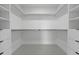 Empty walk-in closet features custom shelving, storage, and tile flooring at 6454 Chorus Dr, Mascotte, FL 34753