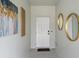 Clean foyer featuring a white door, elegant mirrors, and contemporary art at 6454 Chorus Dr, Mascotte, FL 34753
