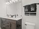 Modern bathroom with a double sink vanity, white countertop, and dark cabinets at 6678 Juneberry Way, Winter Garden, FL 34787