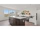 An open concept dining area is adjacent to a large kitchen with stainless steel appliances and wood flooring at 6678 Juneberry Way, Winter Garden, FL 34787