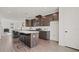 Modern kitchen features sleek dark cabinets, a spacious island with seating, and stainless steel appliances at 6678 Juneberry Way, Winter Garden, FL 34787
