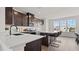 A modern kitchen with dark cabinetry, quartz countertops, and an island with bar seating at 6678 Juneberry Way, Winter Garden, FL 34787