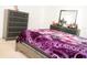 Inviting bedroom shows bed, nightstand, and dresser, all styled with a cozy purple blanket at 707 Staffora St, Haines City, FL 33844