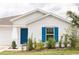Charming single-story home features a blue front door and matching shutters, set against a white exterior at 707 Staffora St, Haines City, FL 33844