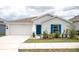 Inviting home exterior with a two-car garage, blue front door, and well-maintained landscaping at 707 Staffora St, Haines City, FL 33844