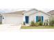 Charming single-story home with a white exterior, blue door and shutters, and an attached garage at 707 Staffora St, Haines City, FL 33844