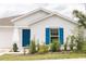 Charming home exterior with a blue door, shutters, and manicured landscaping for curb appeal at 707 Staffora St, Haines City, FL 33844