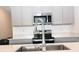 Stylish kitchen featuring a stainless steel sink and appliances set against light gray cabinets at 707 Staffora St, Haines City, FL 33844