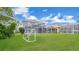 Spacious backyard featuring a well-maintained lawn, screened-in pool, and a soccer goal for recreational activities at 726 Lake Biscayne Way, Orlando, FL 32824