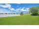 Lush green backyard extending to a tranquil lake, offering picturesque views and ample space for outdoor activities at 726 Lake Biscayne Way, Orlando, FL 32824