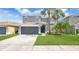 Charming two-story home featuring a gray exterior, well-manicured lawn, and a two-car garage at 726 Lake Biscayne Way, Orlando, FL 32824