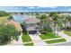 Charming two-story home featuring well-manicured lawn, palm trees, and a serene lake backdrop at 726 Lake Biscayne Way, Orlando, FL 32824