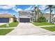 Beautiful gray two-story home with a well-kept lawn, driveway, and tropical palm trees at 726 Lake Biscayne Way, Orlando, FL 32824