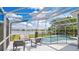 Screened-in pool with comfortable seating overlooking a peaceful lake, perfect for outdoor relaxation and entertainment at 726 Lake Biscayne Way, Orlando, FL 32824
