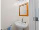 Elegant powder room with a bamboo framed mirror and a pedestal sink with designer faucet at 754 Centervale Dr, Kissimmee, FL 34747